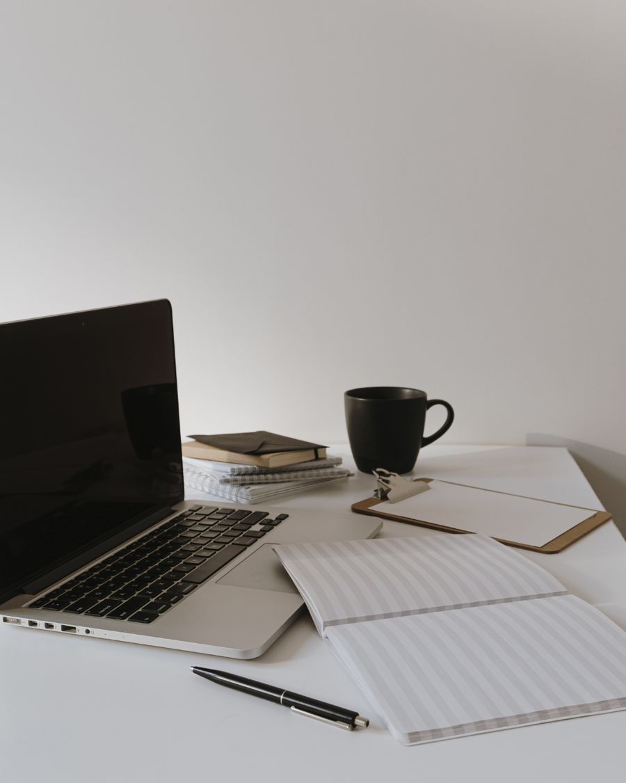 A desk with a laptop and notebook for planning social media content